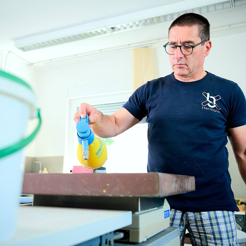 Mitarbeiter von gabex engineers besprüht eine Probe mit Wasser im Labor.