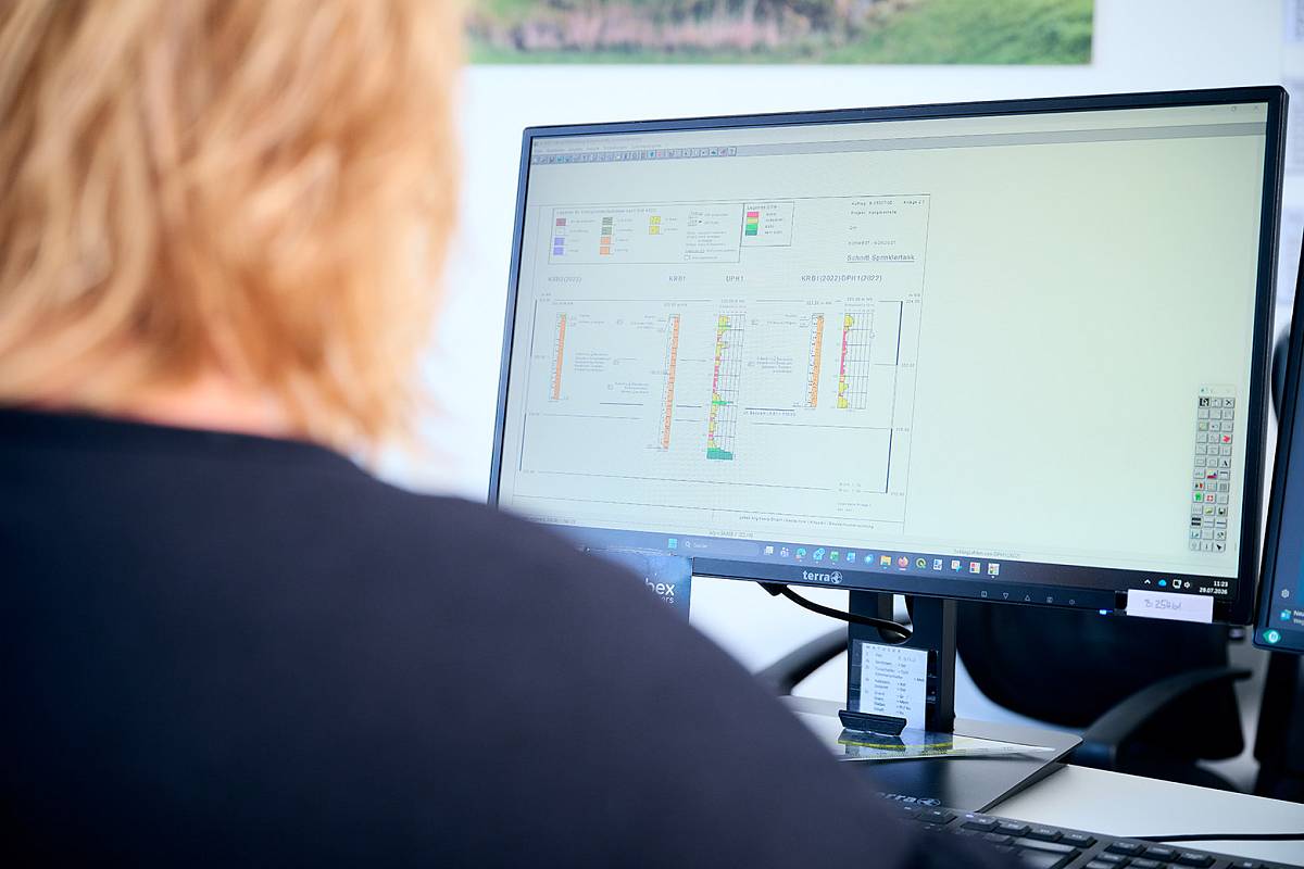Mitarbeiterin von gabex engineers wertet geotechnische Daten und Bohrprofile am Computer aus.