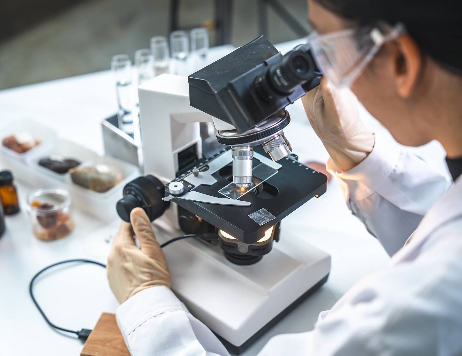 Wissenschaftler untersucht eine Probe unter dem Mikroskop im Labor.