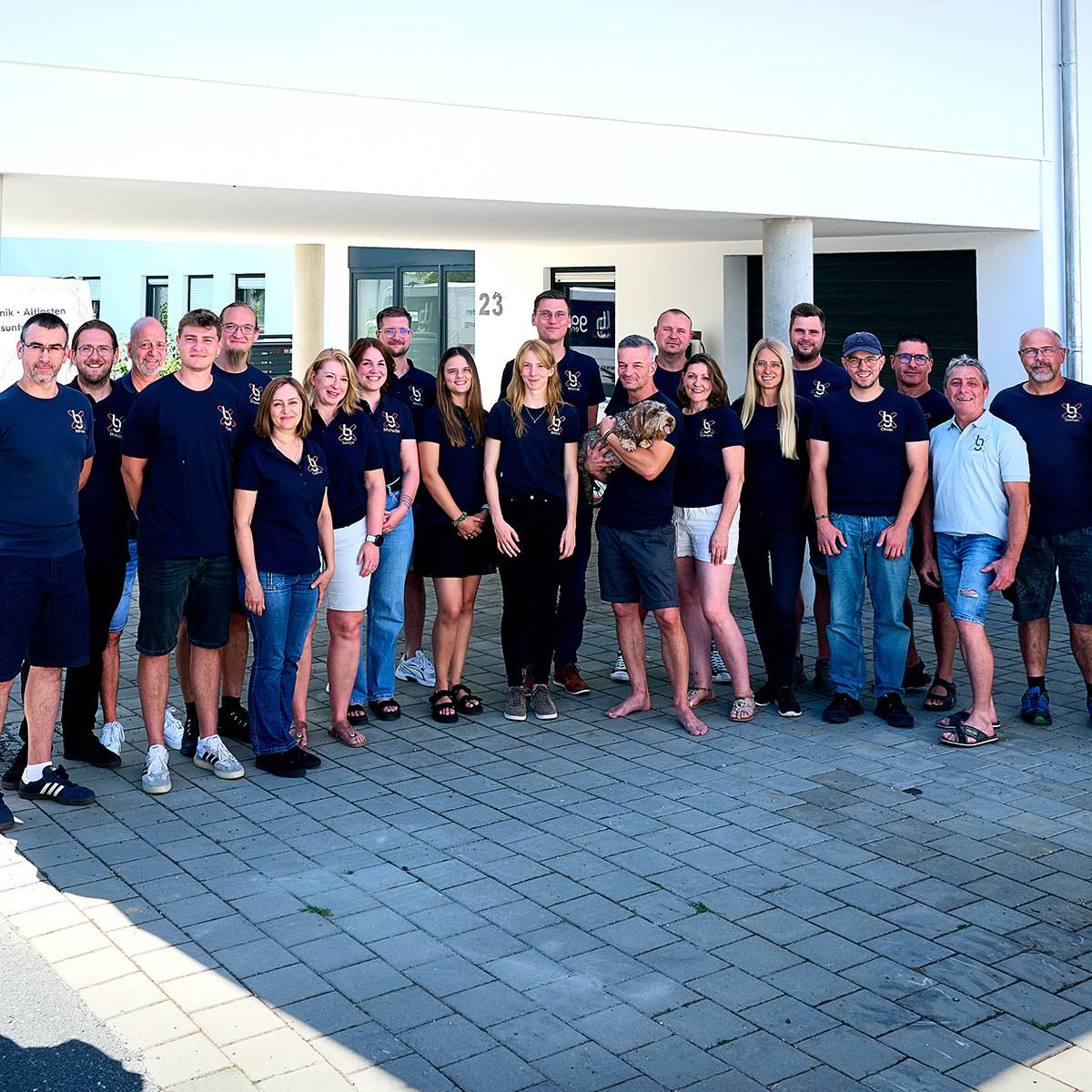 Team von gabex engineers steht gemeinsam vor dem Firmengebäude für ein Gruppenfoto.