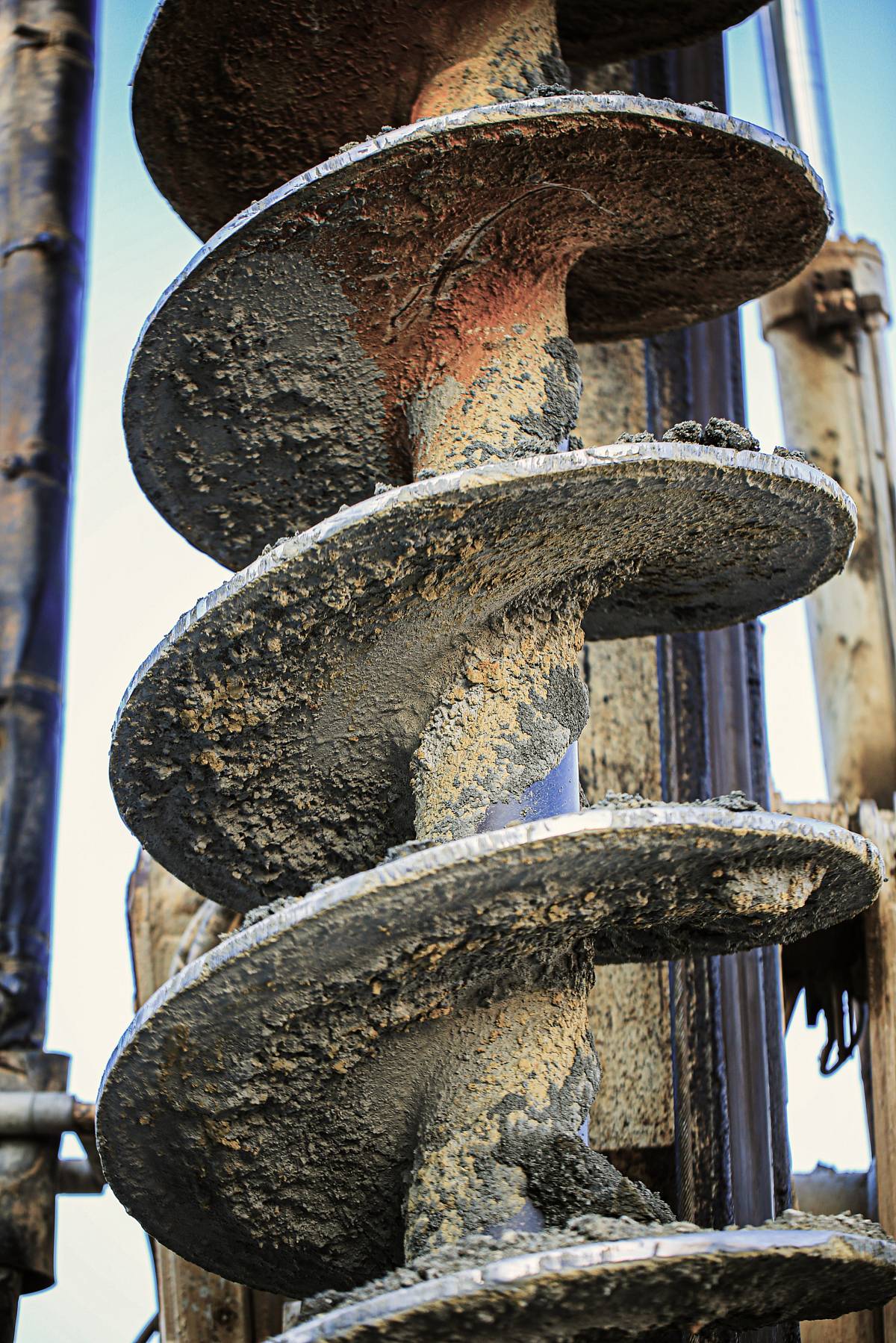 Nahaufnahme einer großen Bohrschnecke mit anhaftendem Erdmaterial bei einer geotechnischen Bohrung.