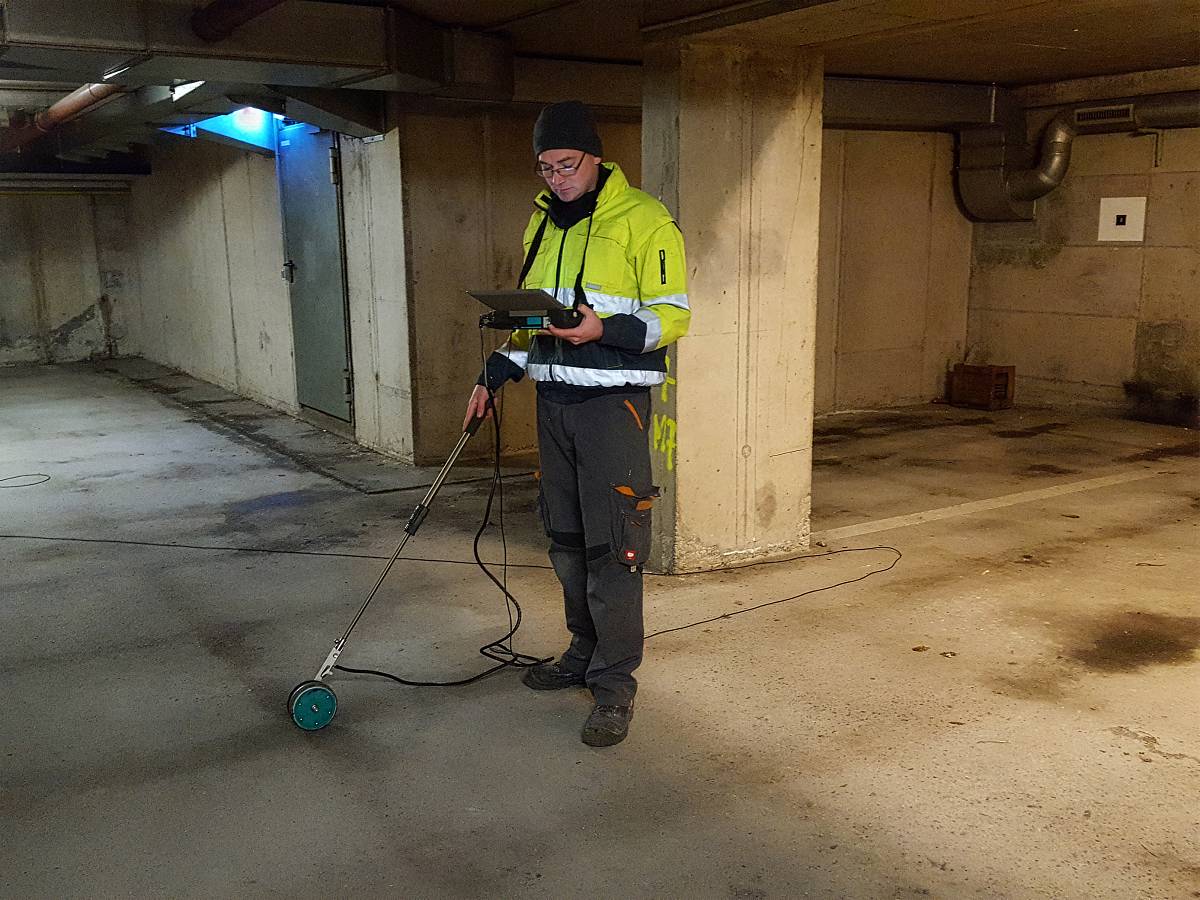 Ingenieur führt eine Potenzialfeldmessung zur Betonanalyse in einem Gebäude durch.