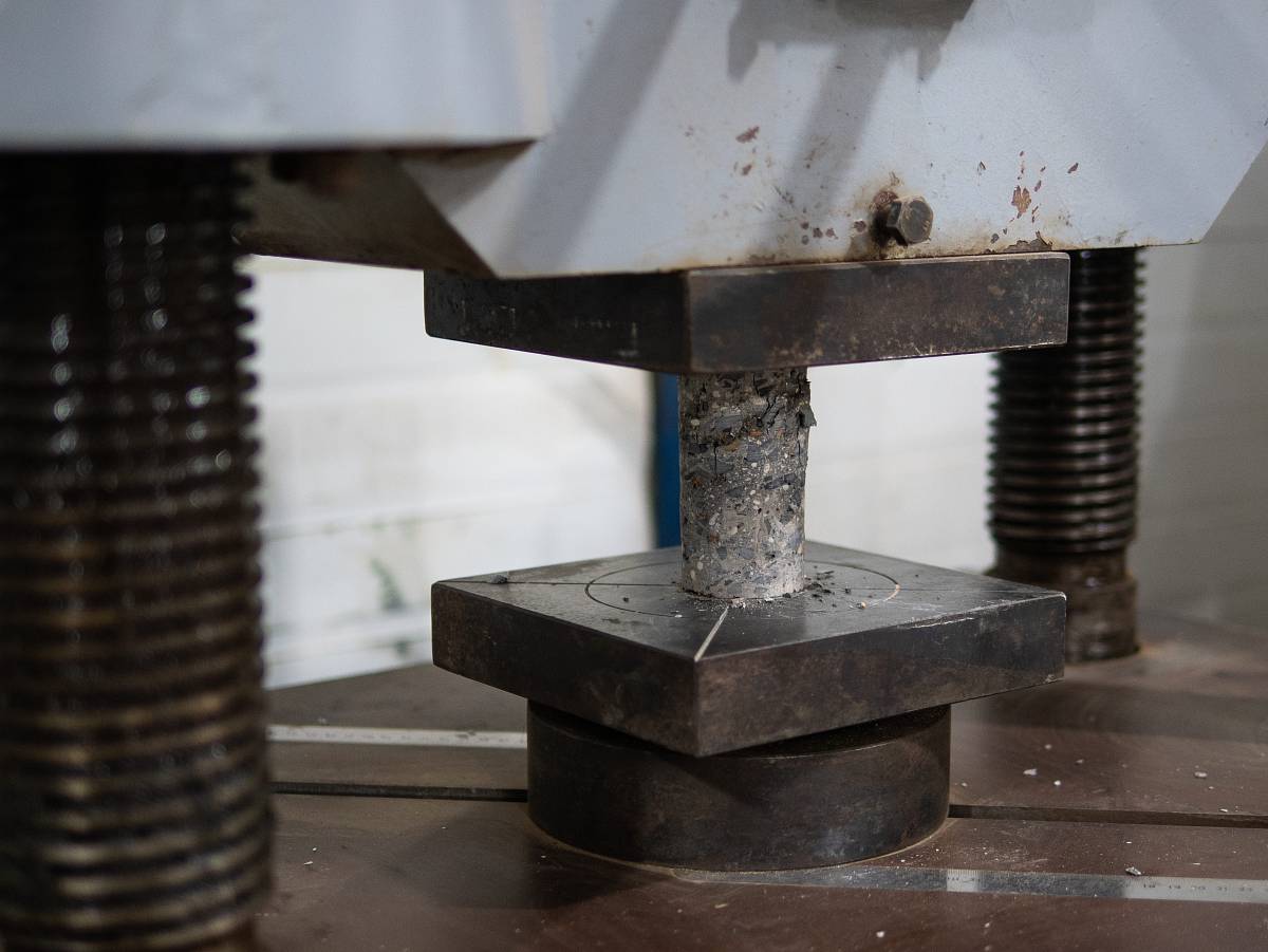 Druckprüfung eines zylindrischen Betonprobekörpers zur Bestimmung der Festigkeit im Labor.