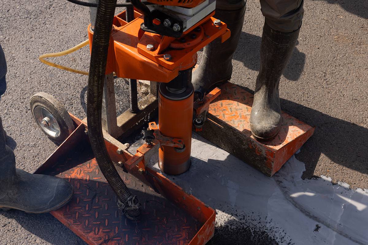 Entnahme einer Betonbohrkernprobe mit Kernbohrgerät auf einer Baustelle.