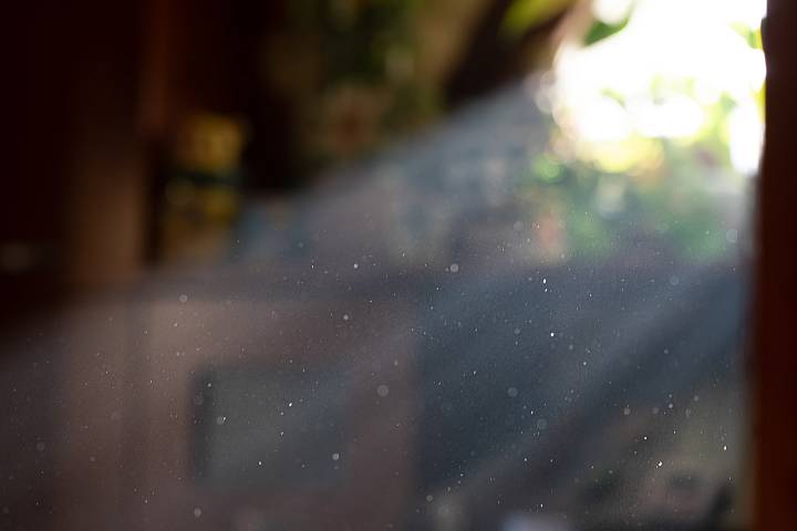 Staub- und Partikelpartikel im Sonnenlicht als Symbol für Luftqualität in Innenräumen