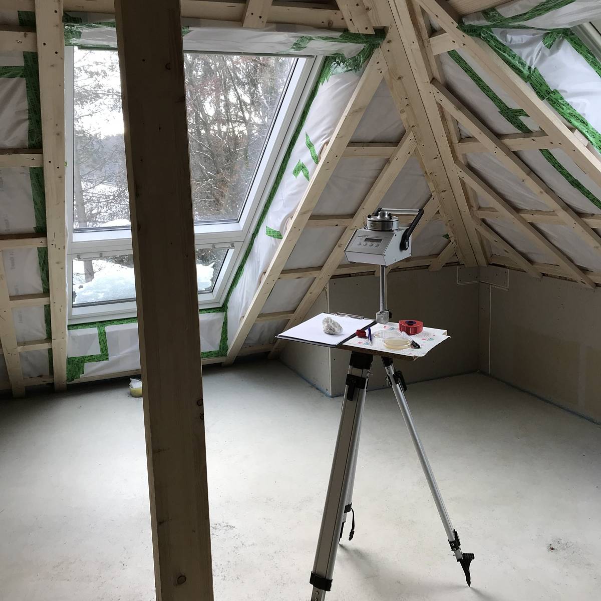 Messgerät zur Raumluftanalyse im Dachgeschoss eines Gebäudes während der Bauphase.