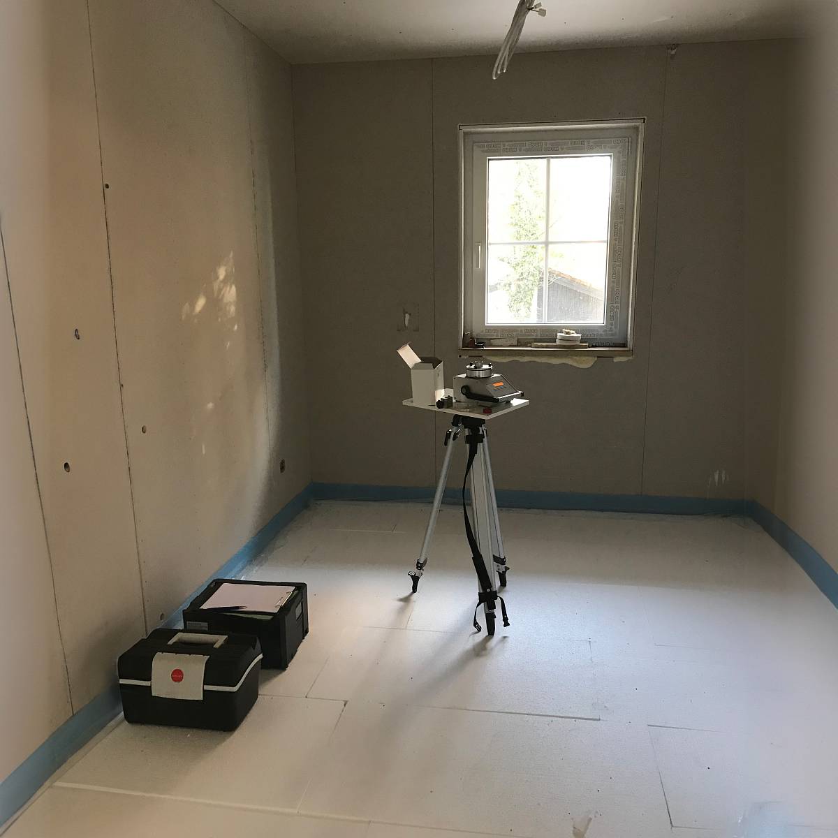 Messgerät zur Raumluftuntersuchung in einem Neubauzimmer während der Bauphase.