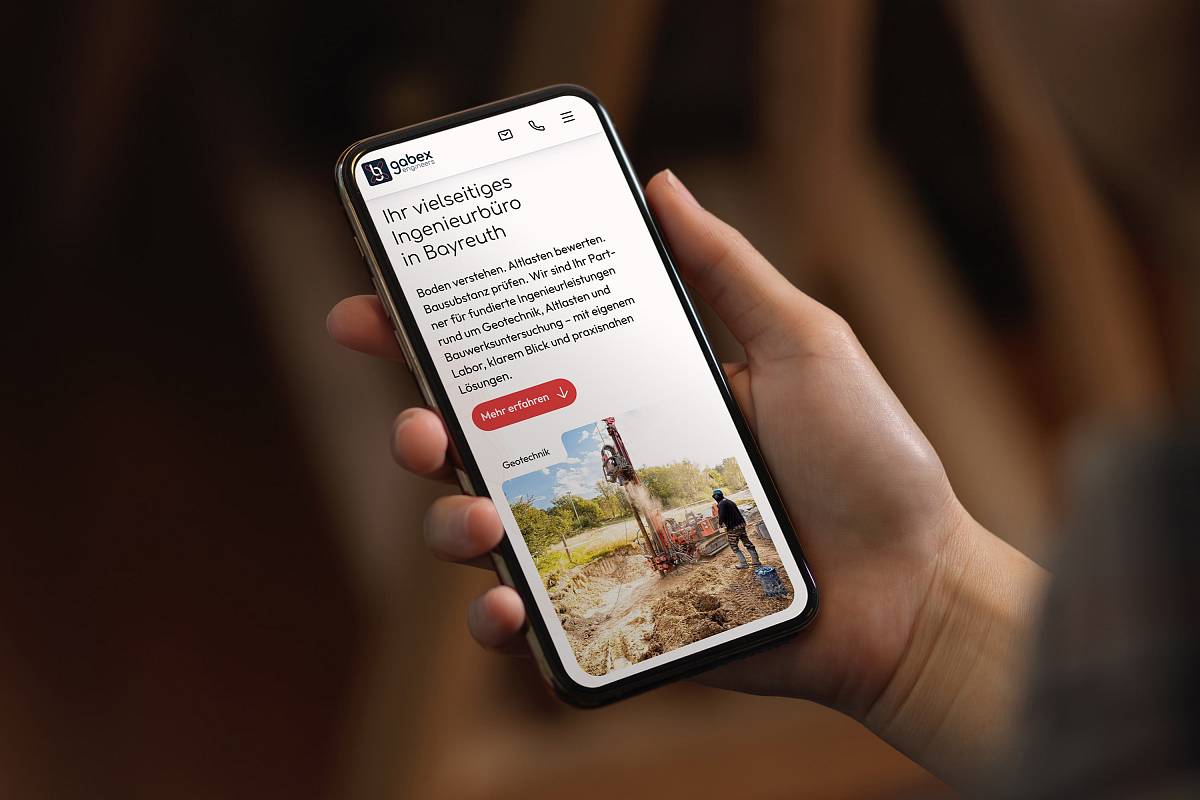 Eine Person hält ein Smartphone in der Hand, auf dessen Bildschirm die Website von gabex engineers angezeigt wird.