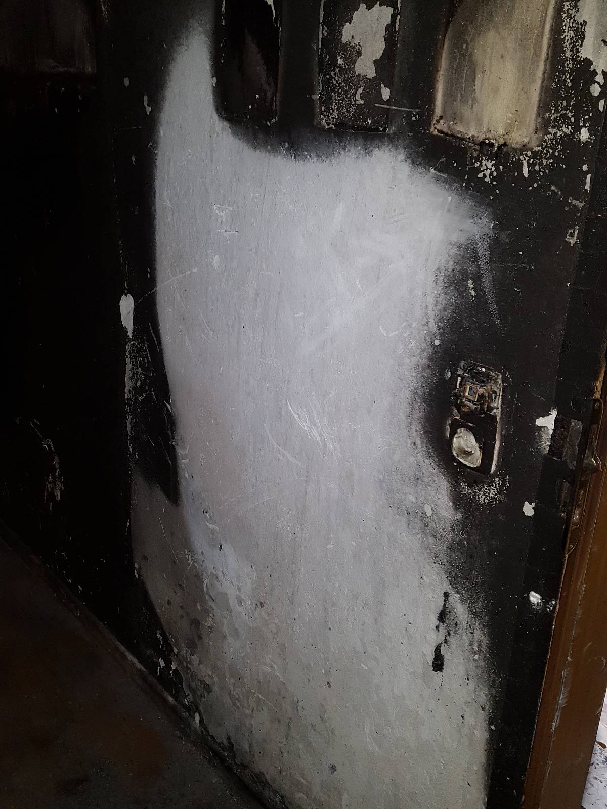 Wand mit deutlichen Brand- und Rußspuren nach einem Feuer, teilweise gereinigt zur Beurteilung von Schadstoffrückständen.