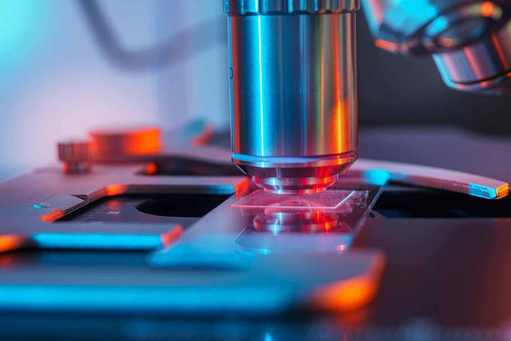 Nahaufnahme von einem Mikroskop mit bunter Beleuchtung.